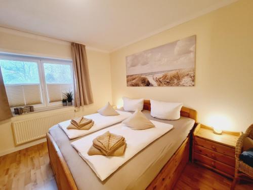 Un dormitorio con dos camas con sábanas blancas. en Fewo Jara, en Kägsdorf