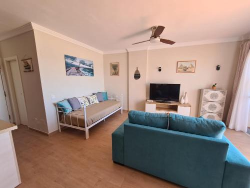 a living room with a blue couch and a television at Apartamento Boquerón I in Sitio de Calahonda
