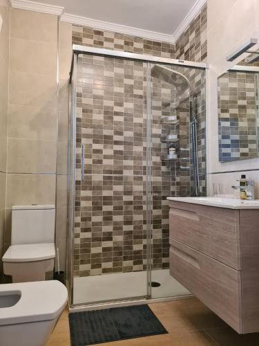 a bathroom with a shower and a toilet and a sink at Apartamento Boquerón I in Sitio de Calahonda
