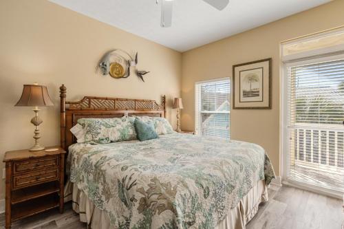 a bedroom with a bed and a lamp and two windows at Casa Del Mar in Panama City Beach