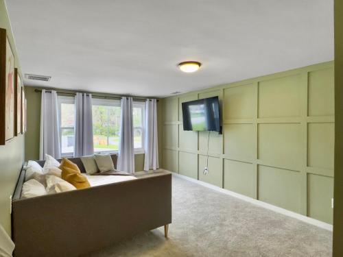 a living room with a couch and a flat screen tv at The Caspian large family house with private pool in Summerville in Summerville