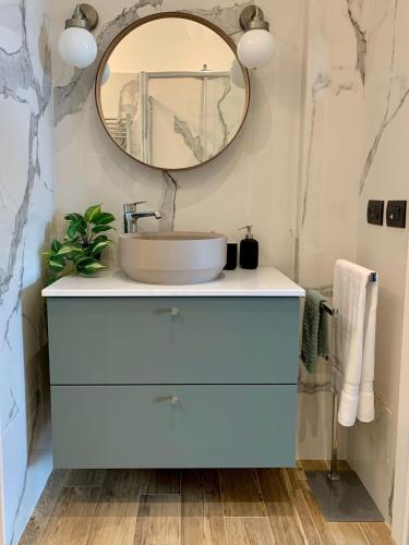 a bathroom with a sink and a mirror at Lettera Luxury Apartment in Formia