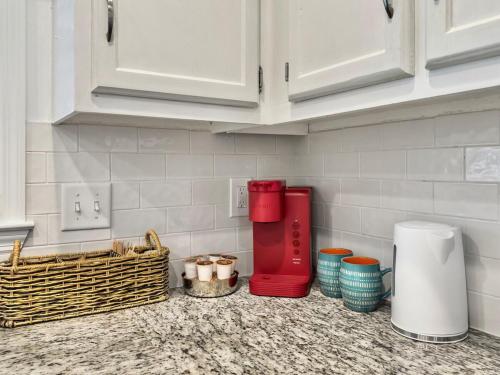 a kitchen counter with a red coffee maker and baskets at The Caspian large family house with private pool in Summerville in Summerville