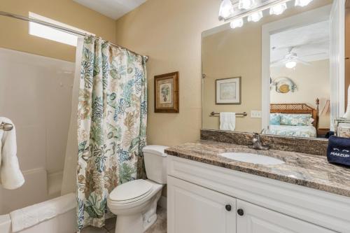 a bathroom with a toilet and a sink and a mirror at Casa Del Mar in Panama City Beach