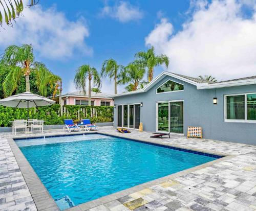 a swimming pool in front of a house at Wonderful Intracoastal Home Heated Pool EastDelray in Delray Beach