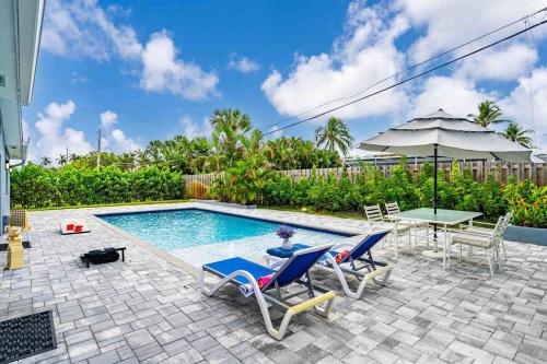 a person sitting in a chair next to a swimming pool at Wonderful Intracoastal Home Heated Pool EastDelray in Delray Beach