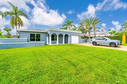 a car parked in front of a house with a yard at Wonderful Intracoastal Home Heated Pool EastDelray in Delray Beach