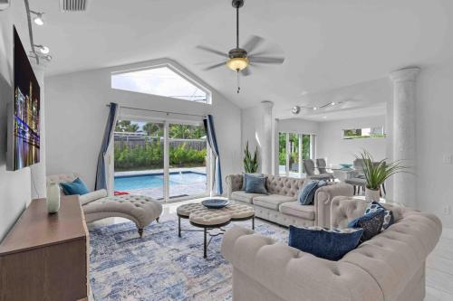 a living room with couches and a table at Wonderful Intracoastal Home Heated Pool EastDelray in Delray Beach