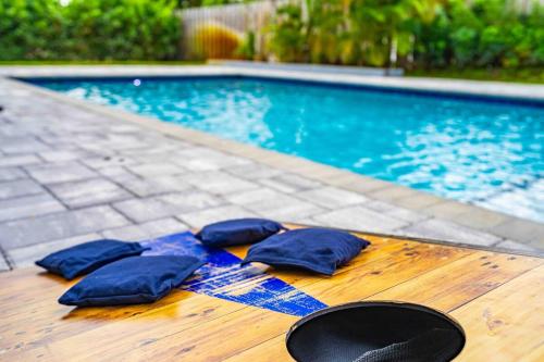 three blue pillows on a wooden table next to a swimming pool at Wonderful Intracoastal Home Heated Pool EastDelray in Delray Beach