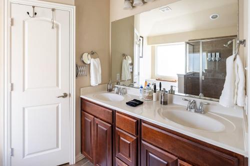 a bathroom with two sinks and a large mirror at Bright and Spacious 3 Bedroom Townhome, Minutes from DFW Airport in Irving