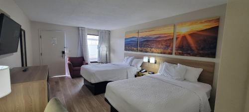 a hotel room with two beds and a television at Days Inn by Wyndham Salem in Salem