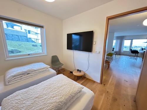 a bedroom with a bed and a flat screen tv at Apartment in Austurkór- Birta Rentals in Reykjavík