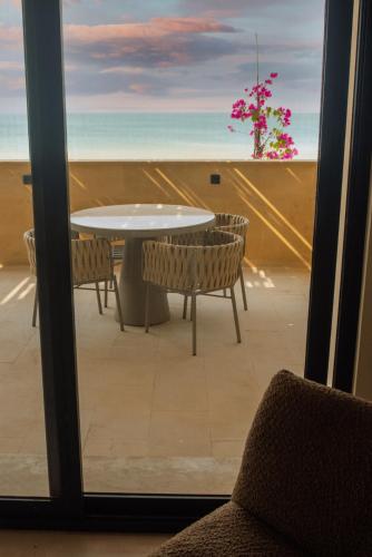 a table and chairs on a balcony with a view of the beach at Khoj Resorts Allana in Karachi