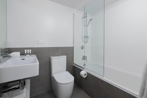 a bathroom with a toilet and a sink and a shower at Quest Parnell Serviced Apartments in Auckland