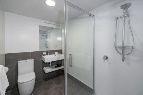 a bathroom with a shower and a toilet and a sink at Quest Parnell Serviced Apartments in Auckland