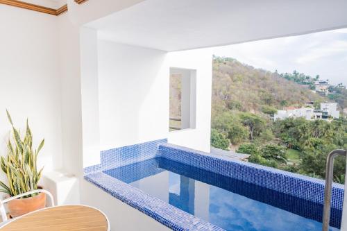 a swimming pool in a house with a window at Condos Privados en Huatulco in Tangolunda