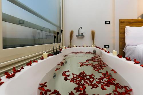 a bath tub filled with red flowers in a room at Rixoss Tower Pyramids View in Cairo