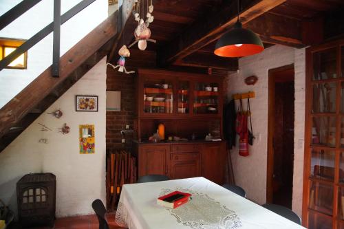 een eetkamer met een tafel en een keuken bij Iemanyá in Villa Gesell