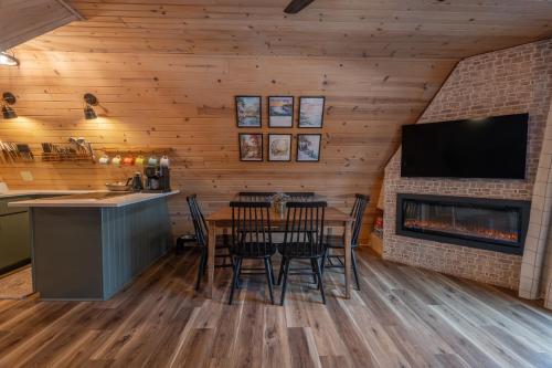 a dining room with a fireplace and a table and chairs at Timber Haven Aframe Cabin - Brand New Hot Tub in Friendship
