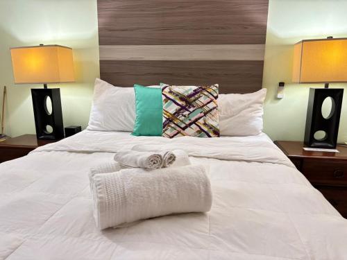a white bed with two towels on top of it at Matthew's Miracle View in Roseau