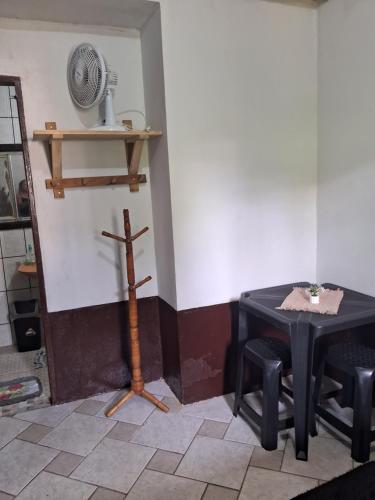 a room with a table and two chairs and a fan at Hostel e Pousada Gratiluz in São Thomé das Letras