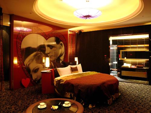 a hotel room with a bed and a poster of a couple at 探索汽車旅館中和館 新北市旅館277-2號 in Zhonghe