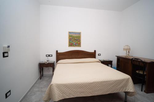 a bedroom with a bed and two tables and a desk at Hotel Caribe in Casalnuovo di Napoli