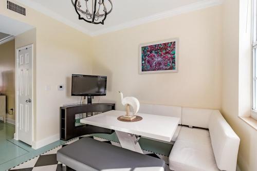 a living room with a white couch and a tv at Spacious 3BR 3BA with King Bed & Amazing Pools near Intercoastal, Lantana Beach, FL in Lantana