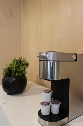 a coffee maker with three cups on a counter at River's Edge Glamping in Clearwater