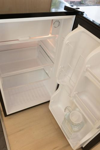 an open refrigerator with its door open and a drawer at River's Edge Glamping in Clearwater