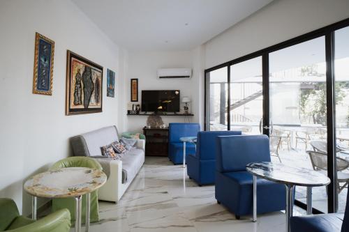 a living room with blue chairs and a tv at Hotel Caribe in Casalnuovo di Napoli