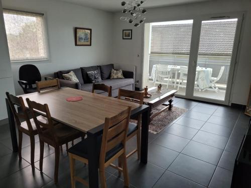 a living room with a wooden table and chairs at Appartement T3 calme avec belle vue in Poisy