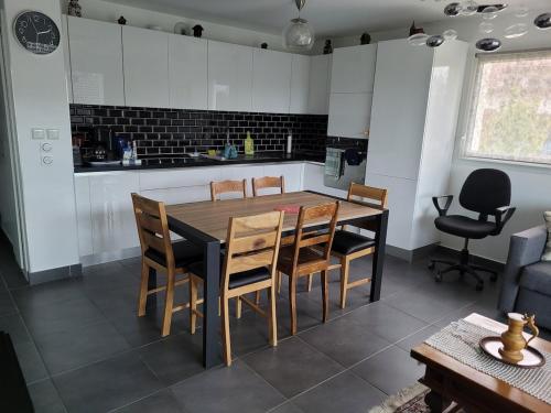 - une cuisine avec une table à manger et des chaises dans l'établissement Appartement T3 calme avec belle vue, à Poisy