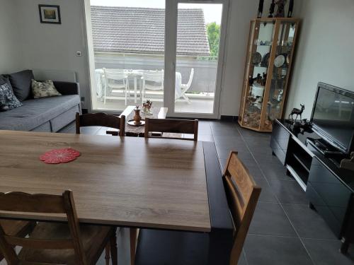 a living room with a wooden table and a couch at Appartement T3 calme avec belle vue in Poisy