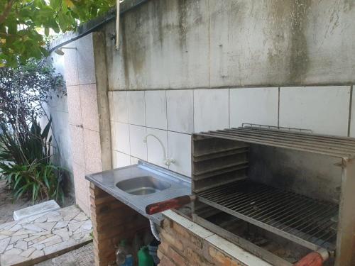 an outdoor kitchen with a sink in a brick wall at Nessa Familia P Frances in Marechal Deodoro