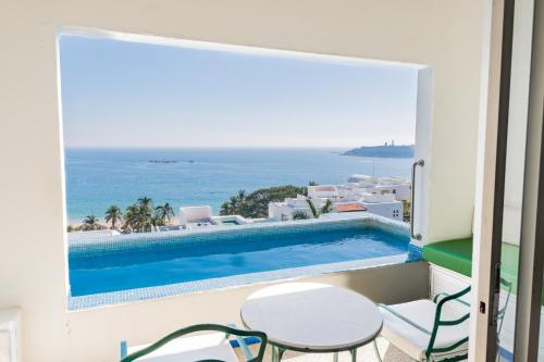 a balcony with a swimming pool and a table and chairs at Condos Privados en Huatulco in Tangolunda