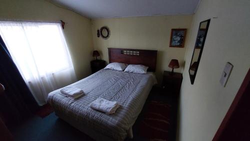 a bedroom with a bed with two towels on it at Casa los Villarroel in Ancud