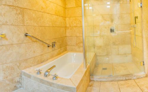 a bathroom with a tub and a shower at Condos Privados en Huatulco in Tangolunda