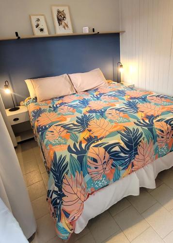 a bedroom with a bed with a colorful bedspread at Lago Argentino Hostel in El Calafate
