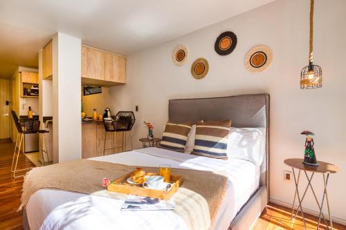 a bedroom with a bed with a tray of food on it at ULIV Condesa in Mexico City