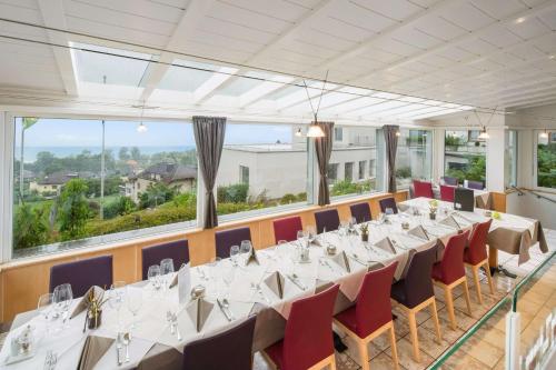 a conference room with tables and chairs and large windows at Best Western Hotel Rebstock in Rorschacherberg