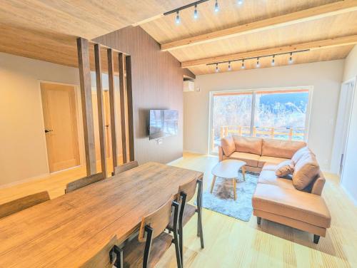 a living room with a table and a couch at Asuka Resort 富士山中湖 in Yamanakako