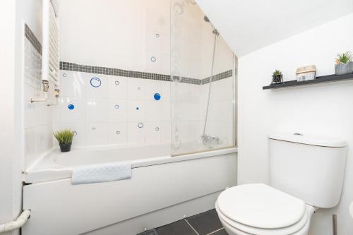 a white bathroom with a toilet and a bath tub at Amazing Lodge in Southampton