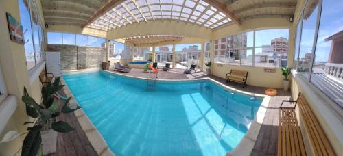 a large swimming pool in a building with a ceiling at Departamento Anthony Refugio del mar in Santa Teresita