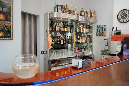 a bar with a counter with a shelf of alcohol at Hotel Caribe in Casalnuovo di Napoli