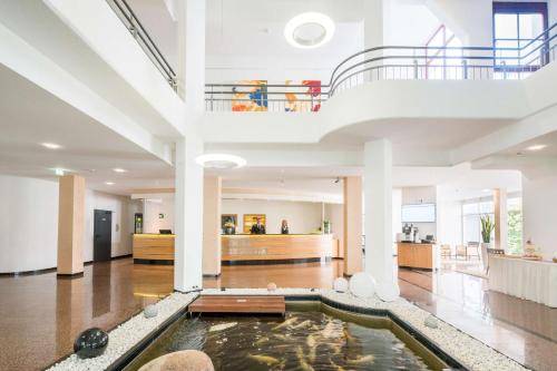 a large lobby with a koi pond in the middle at Best Western Plus Hotel Am Schlossberg in Nürtingen