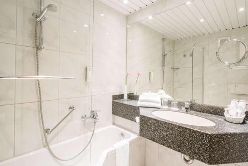 a bathroom with a shower and a sink and a tub at Best Western Plus Hotel Am Schlossberg in Nürtingen