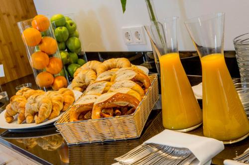 a table with plates of pastries and oranges and juice at Best Western Plus Hotel Am Schlossberg in Nürtingen