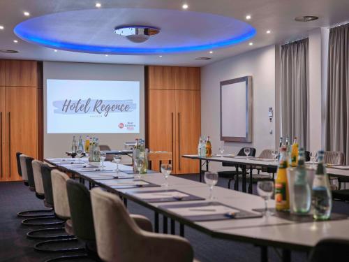 a meeting room with tables and chairs and a projection screen at Best Western Plus Hotel Regence in Aachen