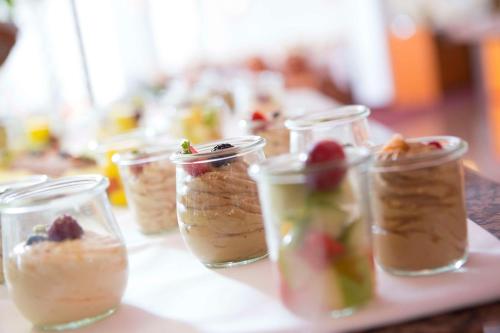 a row of jars filled with desserts on a table at Best Western Plus Hotel Am Schlossberg in Nürtingen